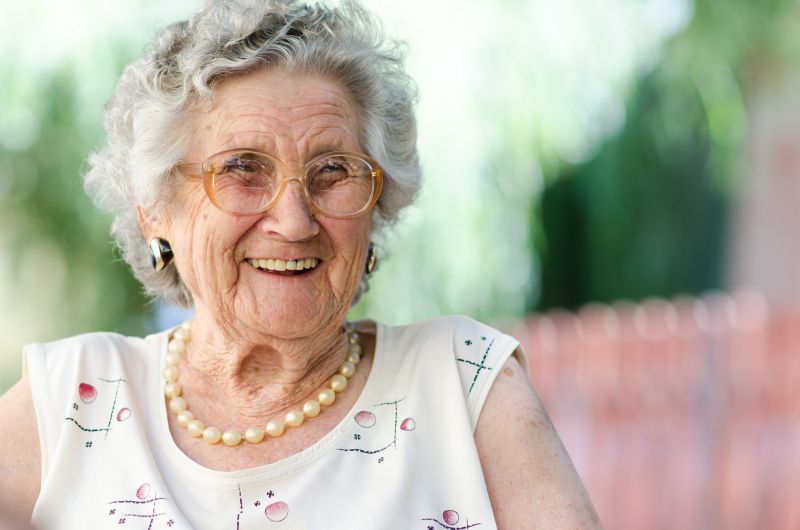 lachende Oma mit Brille im Freien